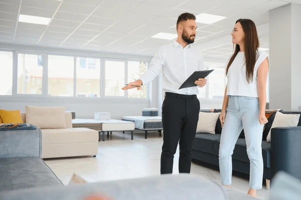 Modern furniture showroom with customer consulting with staff